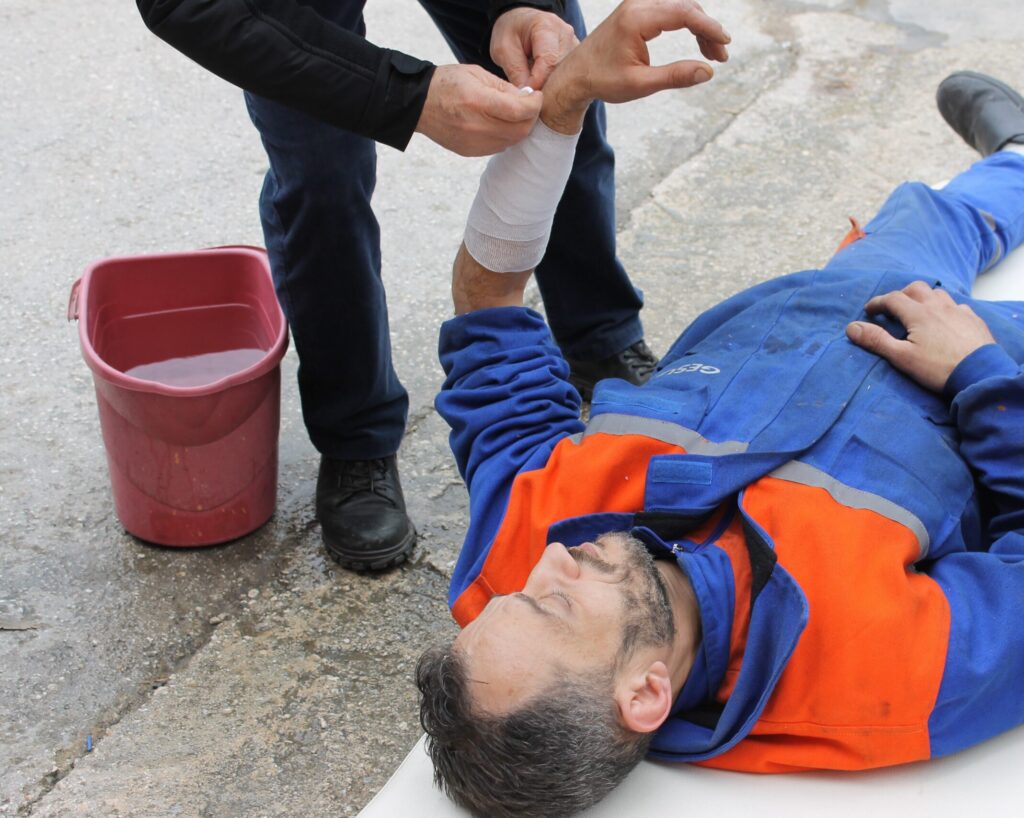 A man lying on the floor receiving first aid treatment